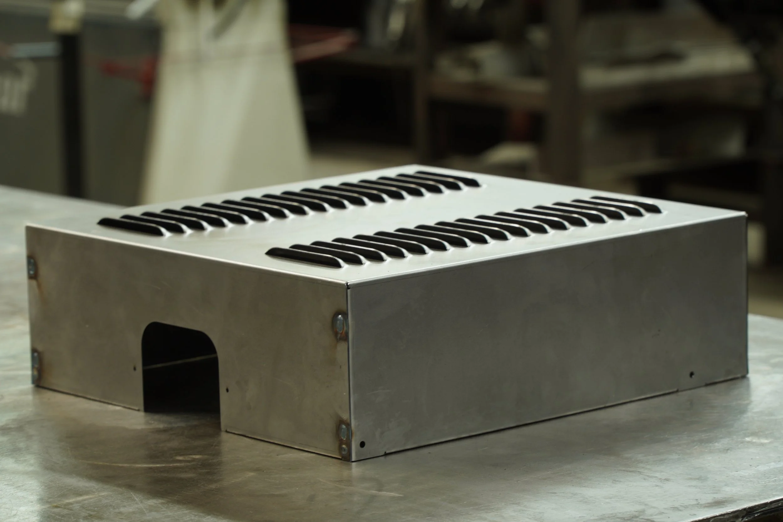 Welded, louvered, and bent sheet metal cover 